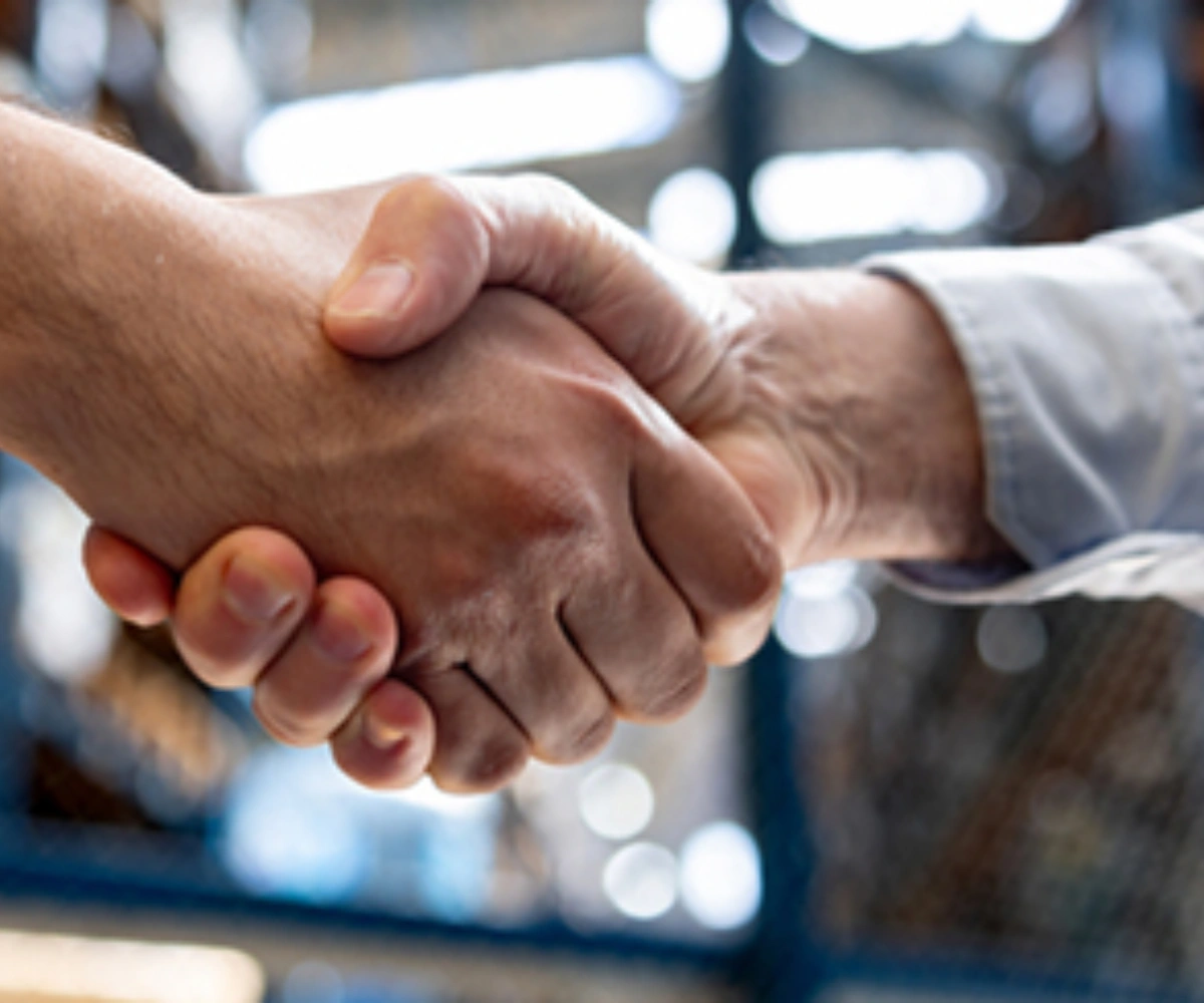 Nærbilde av to hender som hilser med et fast håndtrykk. BIlde.